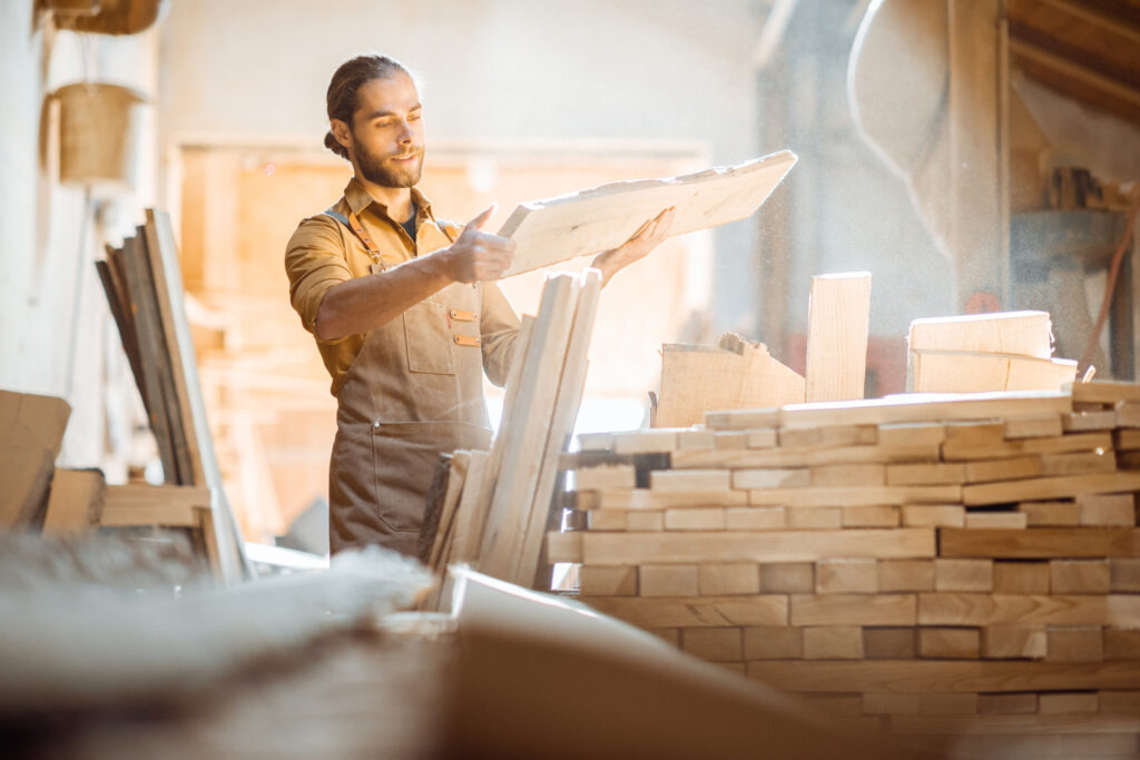 Carpenter choosing raw wood material for a wood-fired hot tub