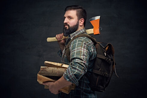 A bearded man with firewood for hot tubs.